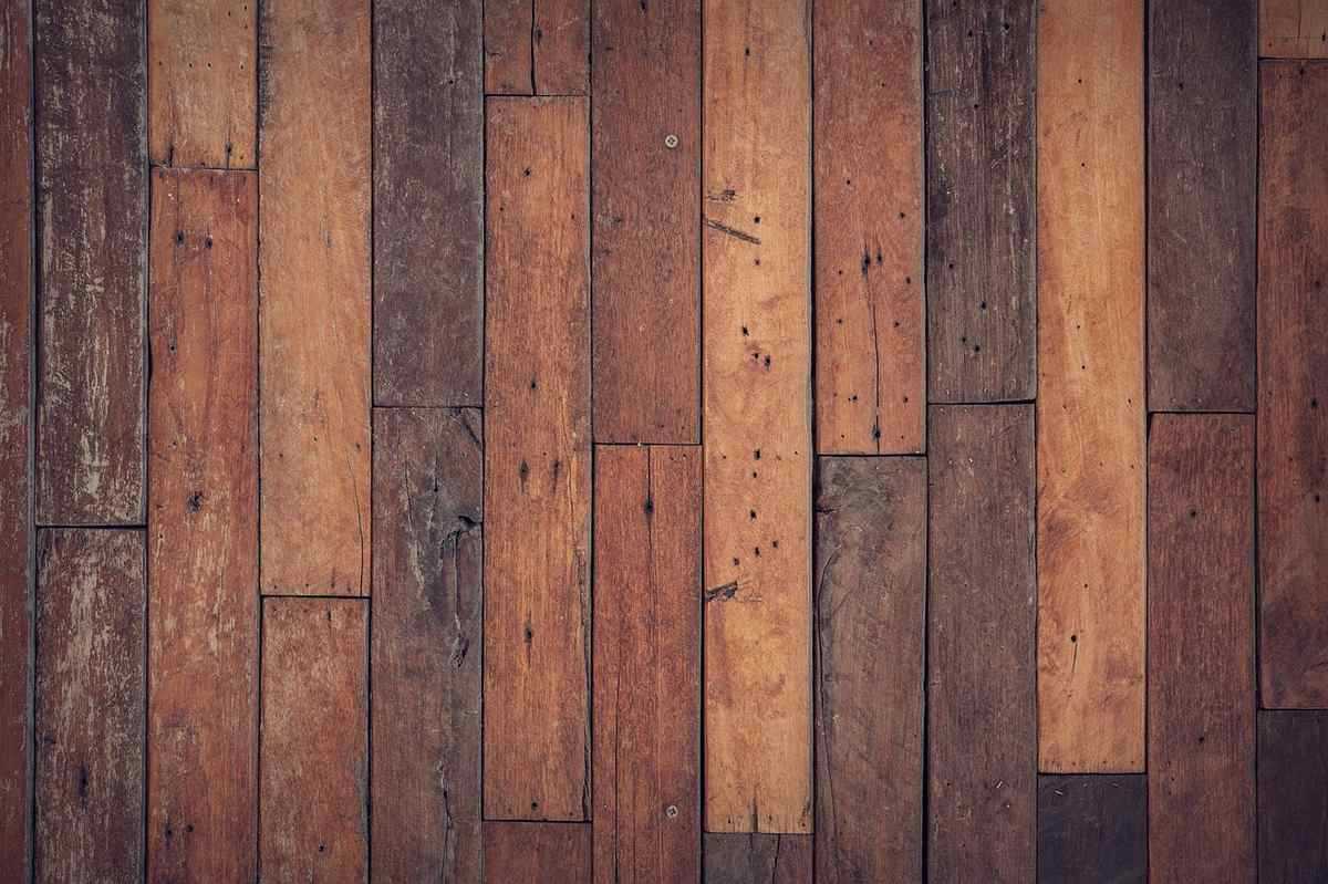 Parquet en bois massif aux nuances marron et auburn, pose en chevrons irréguliers Parquet en bois massif aux nuances marron et auburn, pose en chevrons irréguliers