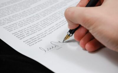 main écrivant sur un document avec un stylo noir